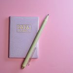 2026 small planner and pen against pink background.