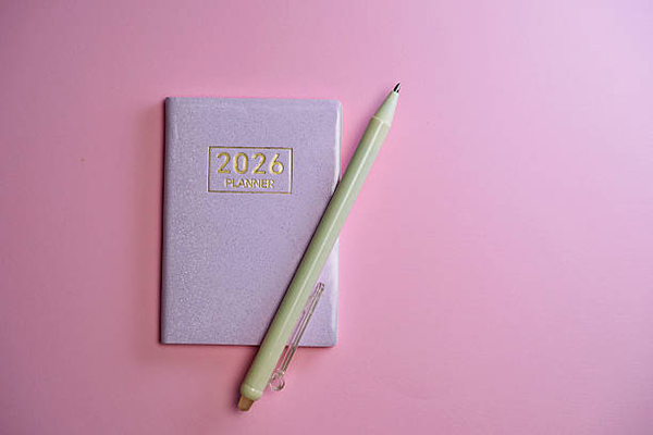 2026 small planner and pen against pink background.