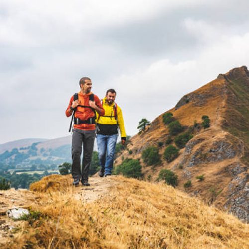 Two men hiking on top of a mountain ridge